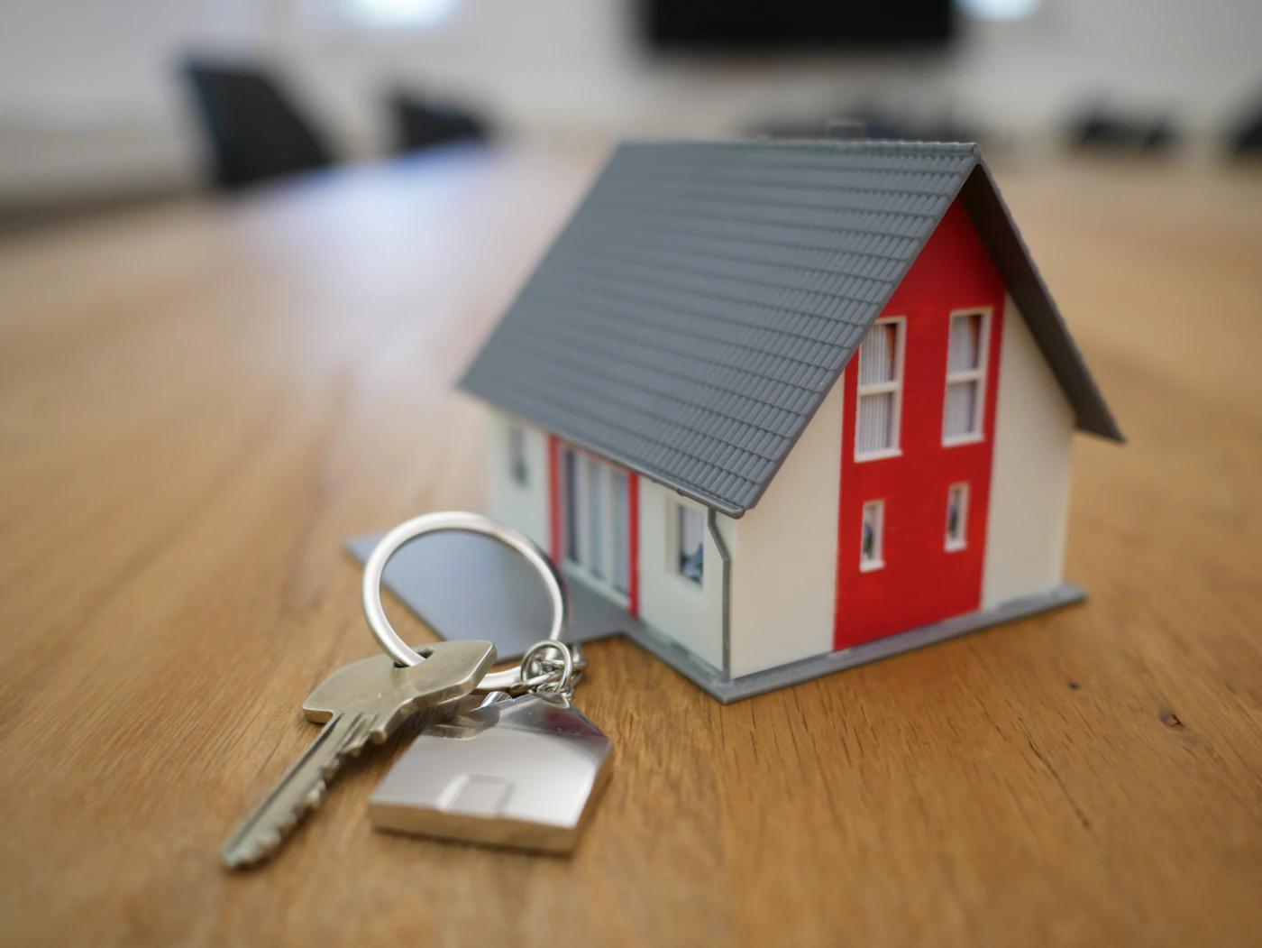 Toy house model with keys resting on paperwork, representing a property investment agreement