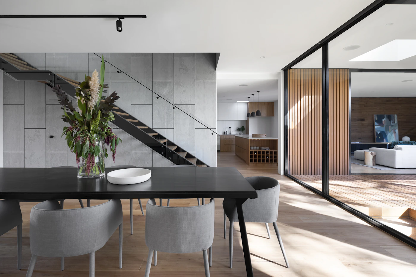 Open-plan modern dining, kitchen, and stairs interior