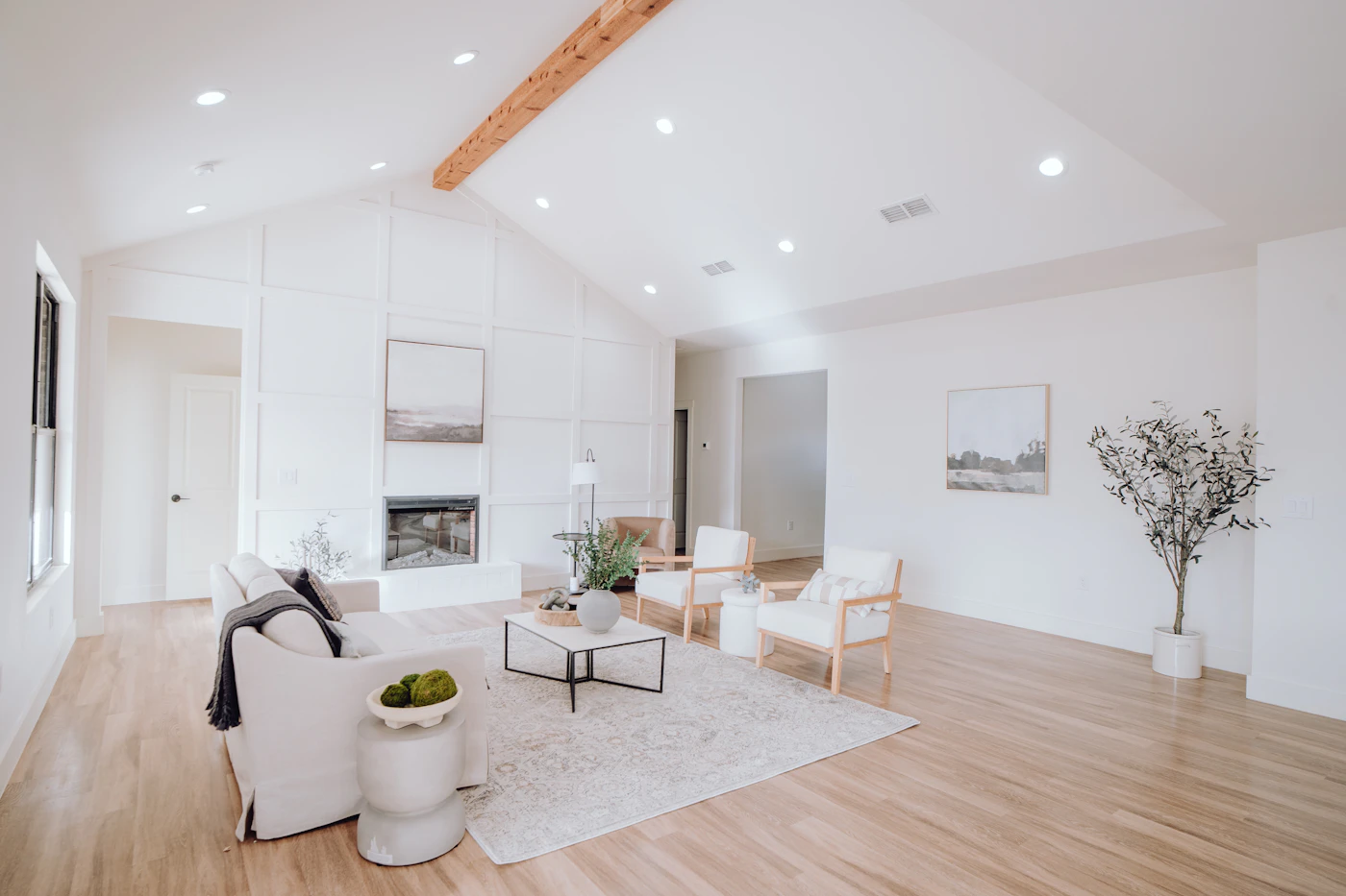 Renovated living room with white furniture and wood floors